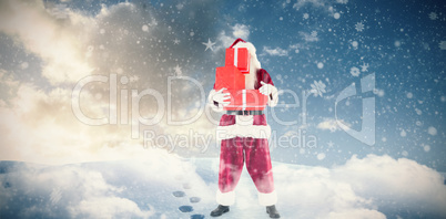 Composite image of santa carrying gifts