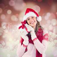 Composite image of attractive woman wearing santa hat with gift