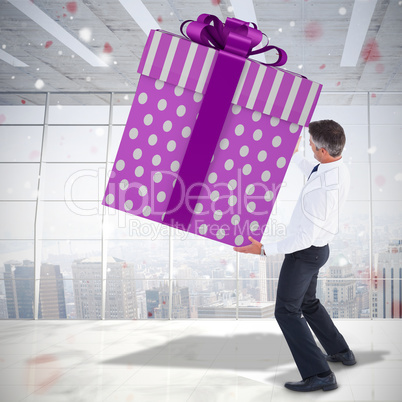 Composite image of stylish man with giant gift