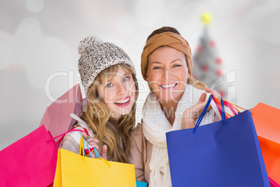 Composite image of beautiful women holding shopping bags looking