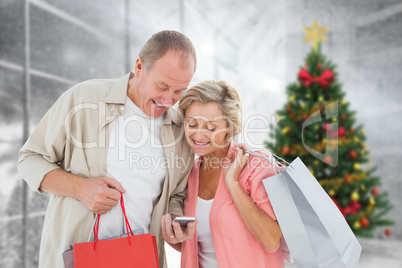 Composite image of couple with shopping bags and smartphone