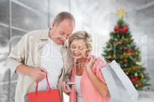 Composite image of couple with shopping bags and smartphone
