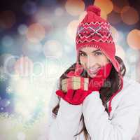 Composite image of surprised brunette in winter clothes holding