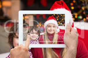 Composite image of hand holding tablet pc