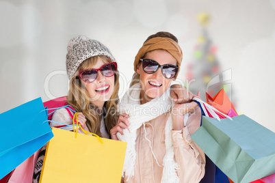 Composite image of beautiful women holding shopping bags looking