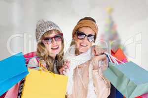 Composite image of beautiful women holding shopping bags looking