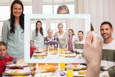 Composite image of hand holding tablet pc