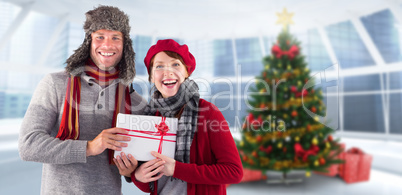 Composite image of couple smiling and holding gift