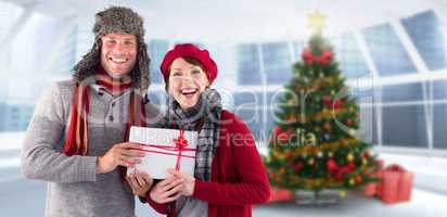 Composite image of couple smiling and holding gift