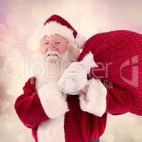 Composite image of santa carries his red bag and smiles