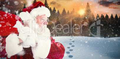 Composite image of santa claus carrying sack