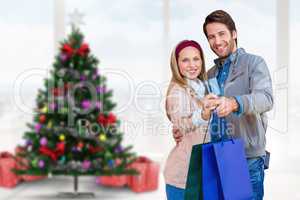 Composite image of smiling couple showing credit card and shoppi