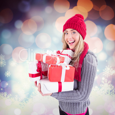 Composite image of festive blonde holding pile of gifts Composite image of festive blonde holding pile of gifts