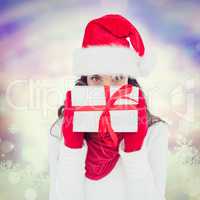 Composite image of brunette in red gloves and santa hat showing