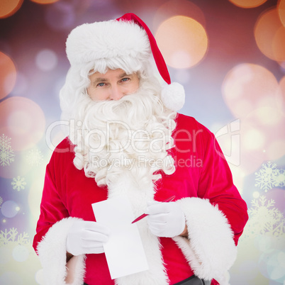 Composite image of happy santa holding paper and pen