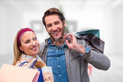 Composite image of smiling couple with shopping bags