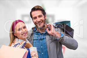 Composite image of smiling couple with shopping bags