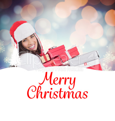 Composite image of festive brunette in winter clothes holding ma