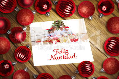 Composite image of christmas baubles on table