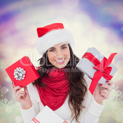 Composite image of happy brunette holding christmas gifts