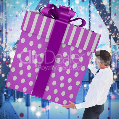 Composite image of stylish man with giant gift