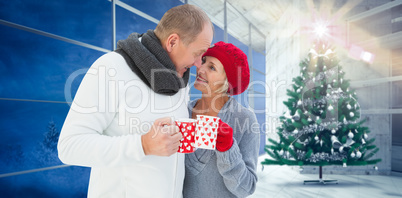 Composite image of mature couple holding mugs