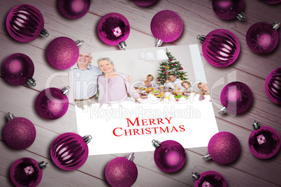 Composite image of christmas baubles on table