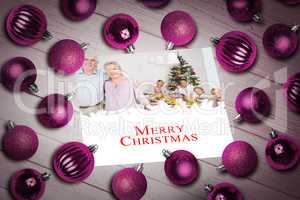 Composite image of christmas baubles on table