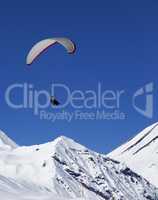 Paraglider in sunny snowy mountains at nice day