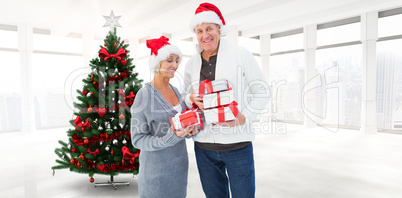 Composite image of festive mature couple holding christmas gifts