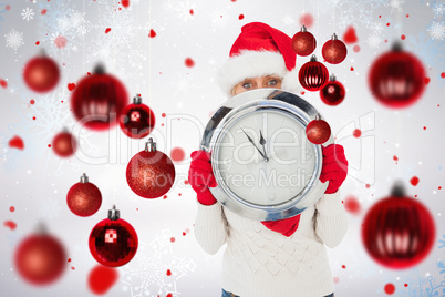 Composite image of festive woman holding clock