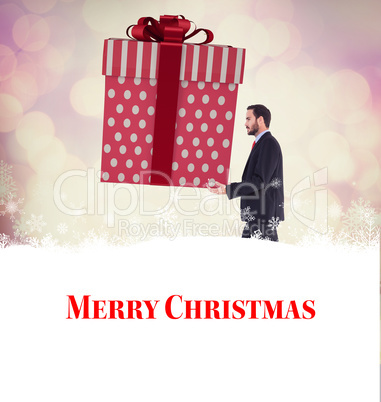 Composite image of stylish man with giant gift