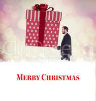 Composite image of stylish man with giant gift