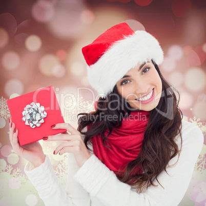 Composite image of joyful brunette presenting christmas gift