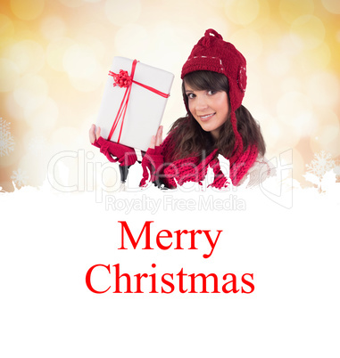 Composite image of smiling brunette showing a gift