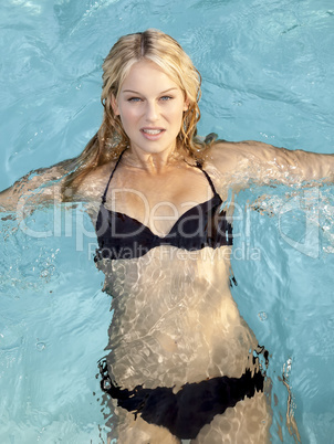 active young blonde woman in a blue pool