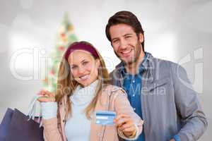Composite image of smiling couple with shopping bags showing cre