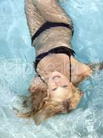active young blonde woman in a blue pool