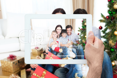 Composite image of hand holding tablet pc