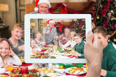 Composite image of hand holding tablet pc