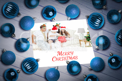 Composite image of christmas baubles on table