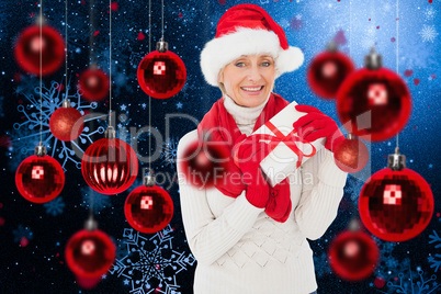 Composite image of festive woman holding gift