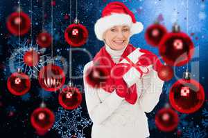 Composite image of festive woman holding gift