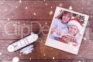 Composite image of smiling siblings holding christmas gifts