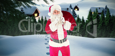 Composite image of santa holding sack and keeping a secret