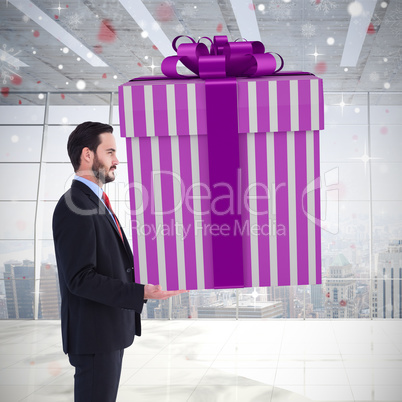 Composite image of stylish man with giant gift