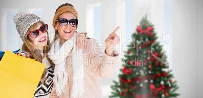 Composite image of beautiful women holding shopping bags pointin