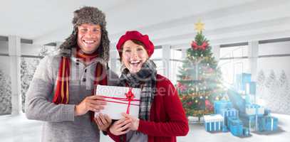 Composite image of couple smiling and holding gift