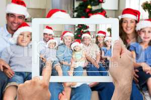 Composite image of hand holding tablet pc