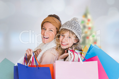 Composite image of beautiful women holding shopping bags looking